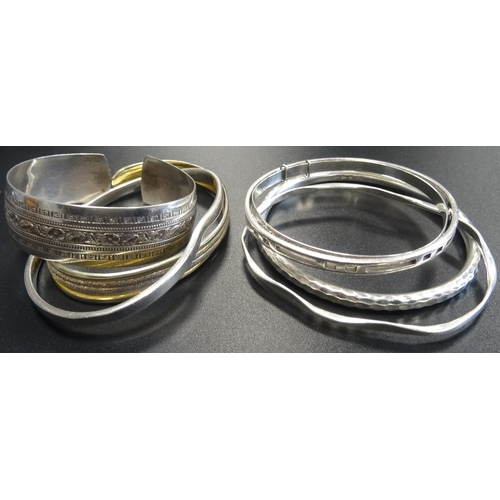 23 - SEVEN SILVER BANGLES
of various sizes and designs