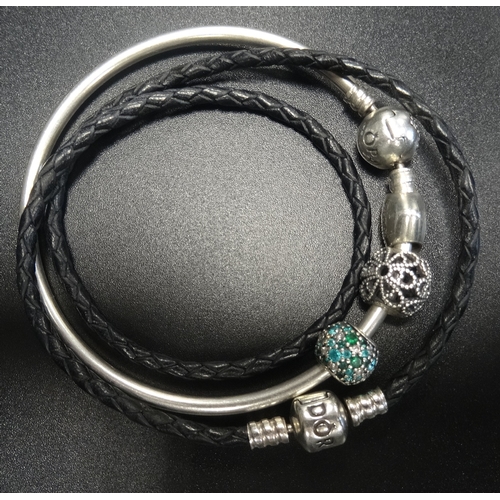 93 - PANDORA MOMENTS SILVER BANGLE WITH STAR DECORATED CLASP
and three charms; together with a black doub... 