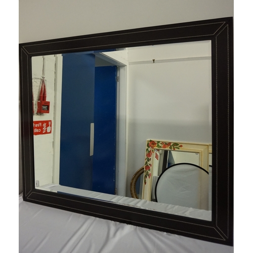 415 - LARGE STAINED OAK FRAME MIRROR
with inset leather panels with decorative stitching, encasing a bevel... 