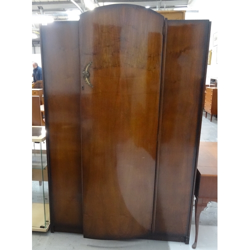 471 - 1930'S MAHOGANY BOW FRONT WARDROBE
with a central arched door opening to reveal hanging rails and a ... 