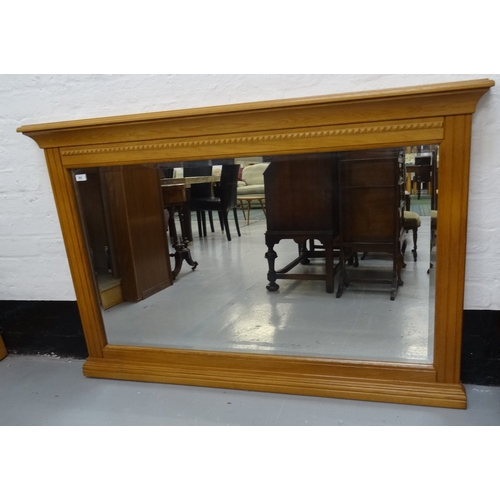 393 - LIGHT OAK OVERMANTLE MIRROR
with a bevelled plate in a moulded and carved oak frame, 98cm x 150cm ov... 