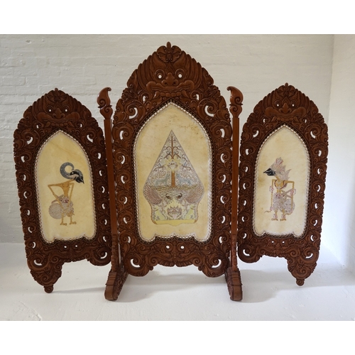 86 - LARGE INDONESIAN HEAVILY CARVED TEAK 'SKETSEL WAYANG' 
in three sections, the frame decorated with m... 