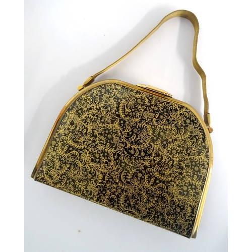 252 - 1950s HARD SHELL EVENING BAG BY STRATTON
with floral gilt decoration on a black ground, opening to r... 