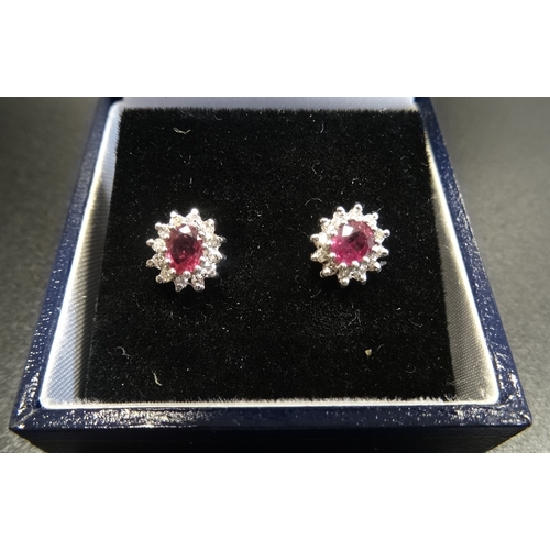 95 - PAIR OF RUBY AND DIAMOND CLUSTER EARRINGS
the central ruby on each in twelve diamond surround, in ni... 