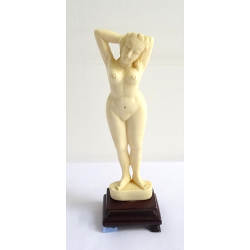 192 - EARLY 20th CENTURY IVORY CARVING OF A NUDE LADY
with both hands in her hair, raised on a shaped stai... 