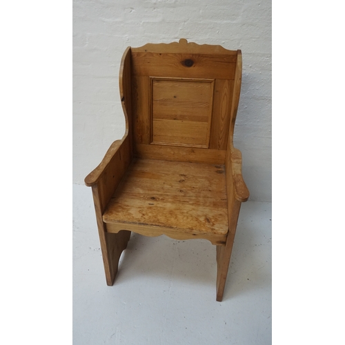 424 - WAXED PINE ARMCHAIR
with a shaped panelled back and sides above a solid seat, standing on carved sol... 