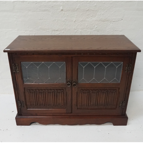 426 - WOOD BROTHERS OAK SIDE CABINET
with a moulded top above a pair of panelled doors with carved linen f... 