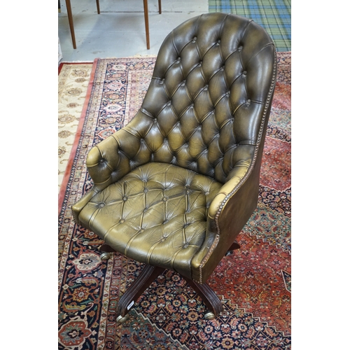 407 - TAN LEATHER CHESTERFIELD SWIVEL ARMCHAIR
raised on pedestal support with frame on castors