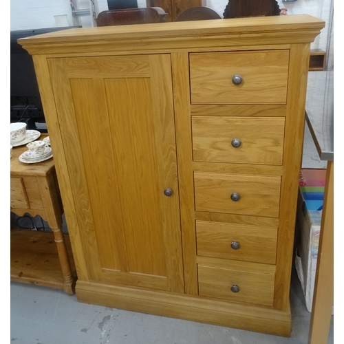 412 - OAK DRESSING CHEST
with a moulded top above a panelled cupboard door opening to reveal a hanging rai... 