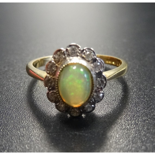 19 - OPAL AND DIAMOND CLUSTER RING
the central opal in twelve diamond surround, on eighteen carat gold sh... 
