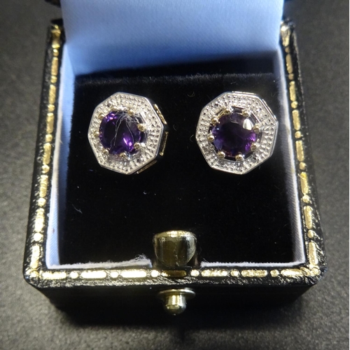 113 - PAIR OF AMETHYST AND DIAMOND EARRINGS
the central round cut amethyst on each within textured surroun... 