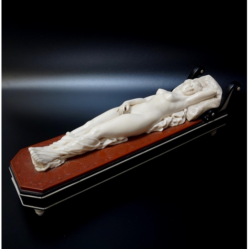 278 - 19th CENTURY CONTINENTAL CARVED IVORY RECLINING NUDE FEMALE
reclining on a day bed, her head on a fl... 