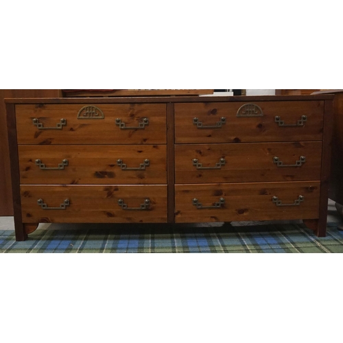 527 - LARGE PINE EFFECT CHEST
with an arrangement of six drawers, standing on plain supports, 155cm long  ... 