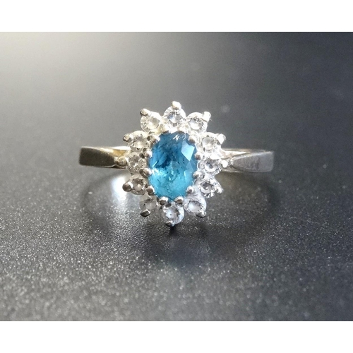 95 - BLUE TOPAZ AND CLEAR GEM SET CLUSTER RING
the central oval cut blue topaz in clear gem surround, on ... 