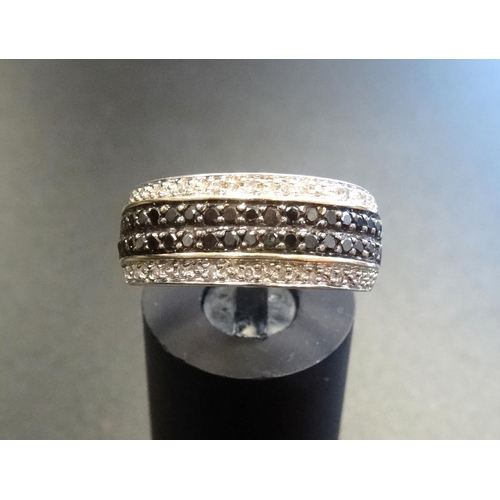 160 - BLACK AND WHITE DIAMOND CLUSTER RING
the double row of black diamonds with a row of white diamonds a... 