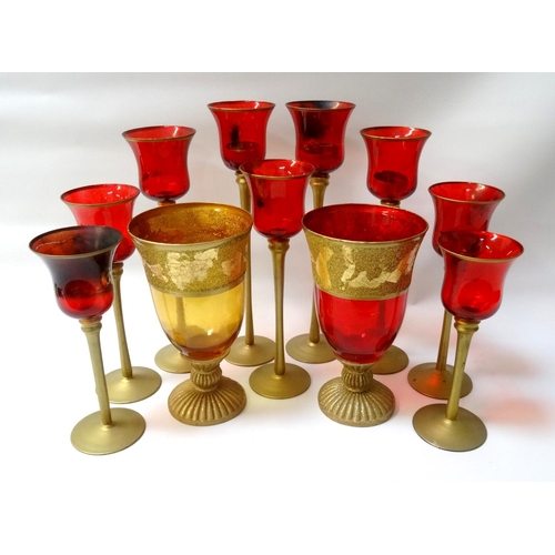 213 - SELECTION OF DECORATIVE GLASS TEA LIGHT HOLDERS
nine of graduated size with ruby red bowls on gold s... 