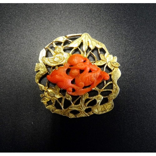 121 - CHINESE SILVER GILT AND CORAL BROOCH
the central carved coral section depicting a bird and water mot... 