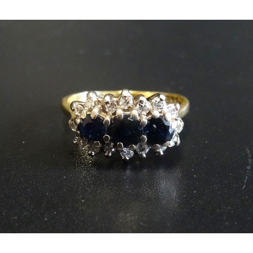 104 - SAPPHIRE AND DIAMOND CLUSTER DRESS RING
the three sapphires in diamond surround, on eighteen carat g... 