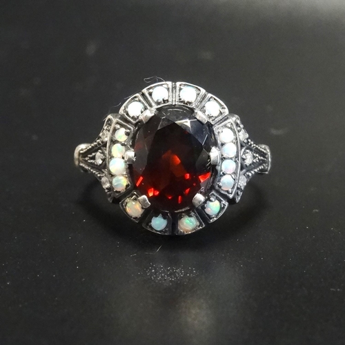 172 - GARNET, OPAL AND DIAMOND CLUSTER RING
the central oval cut garnet in opal surround with small diamon... 