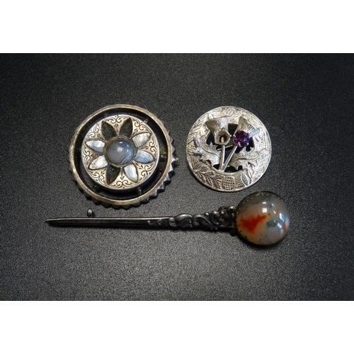 102 - THREE SCOTTISH SILVER BROOCHES
comprising a circular agate set example, a moss agate set kilt pin in... 