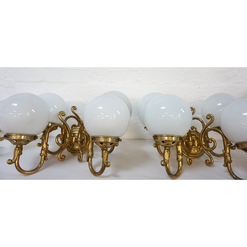 530 - SET OF FOUR GILT BRASS WALL LIGHTS
each with a pair of scroll arms and opaque circular glass shades ... 