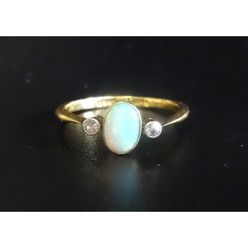 9 - OPAL AND DIAMOND THREE STONE RING
the central oval opal flanked by diamonds, on eighteen carat gold ... 