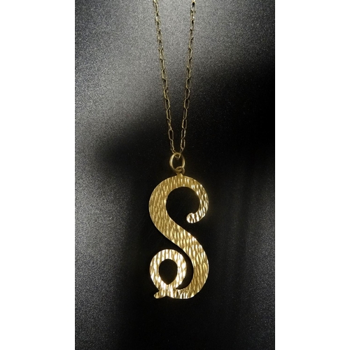 1 - NINE CARAT GOLD 'S' SHAPED PENDANT
with textured detail, on nine carat gold chain, total weight appr... 