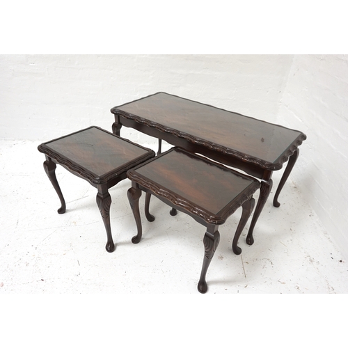 410 - MAHOGANY NEST OF TABLES
each with a wavy edge and an inset glass top, standing on cabriole supports,... 