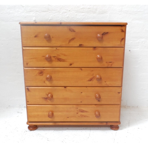 476 - PINE CHEST
with a moulded top above five long drawer with turned handles, standing on flattened bun ... 