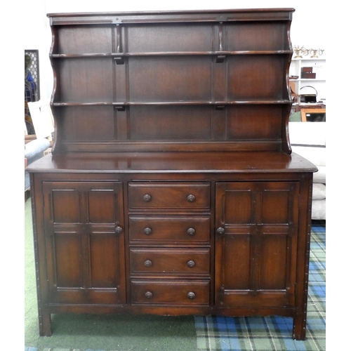 495 - ERCOL STAINED OAK DRESSER
with a raised plate rack back with shelves and shaped sides, above a base ... 