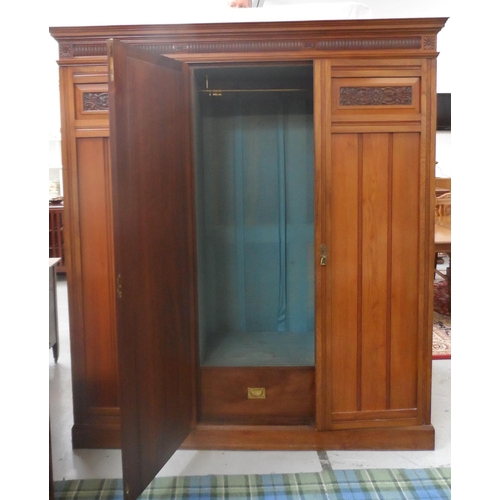 497 - EDWARDIAN WALNUT WARDROBE
with a carved pediment above a central bevelled mirror door flanked by a p... 