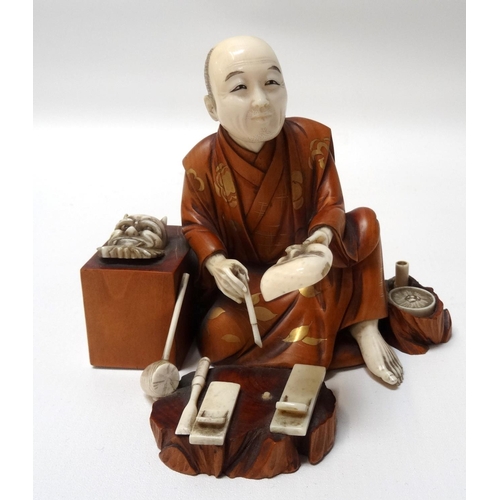 283 - CARVED JAPANESE IVORY AND BOXWOOD OKIMINO
of a Noh mask maker, seated with his masks and tools aroun... 