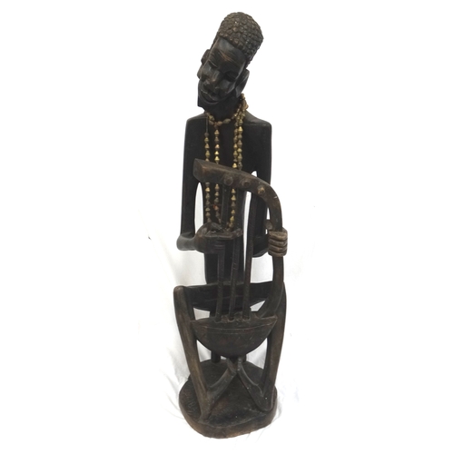 280 - SIGNED CARVED AFRICAN WOODEN FIGURE
of a story teller playing a three string Bolon seated on a stool... 