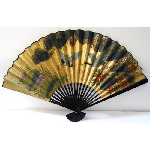 289 - DECORATIVE CHINESE FAN
of large size with ebonised sticks, the paper with a gold ground decorated wi... 