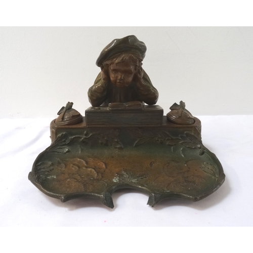 322 - EARLY 20TH CENTURY SPELTER DESK STAND
depicting a young boy reading a book flanked by a pair of inkw... 