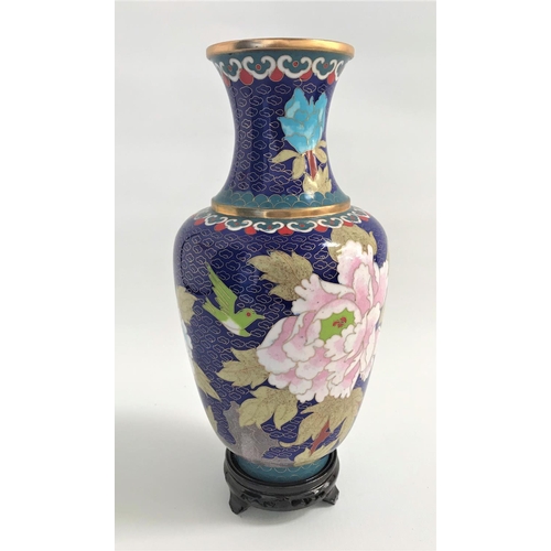 319 - CHINESE CLOISONNE VASE
with a blue ground decorated with flowers, 25.5cm high, with a circular wood ... 