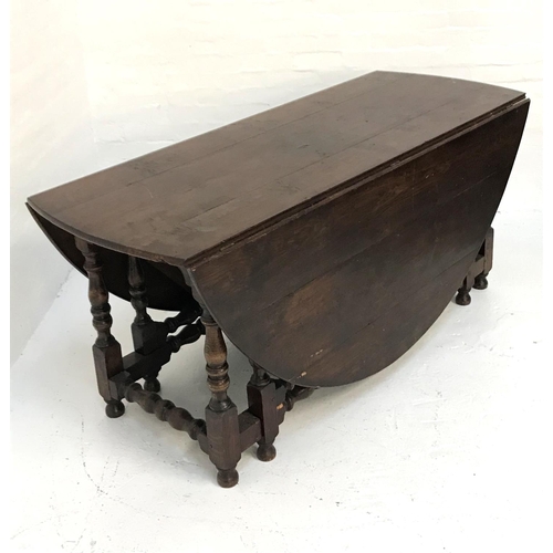 518 - VERY LARGE OAK GATELEG TABLE
with shaped drop flaps, standing on turned supports united by stretcher... 