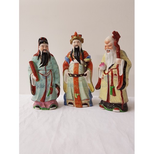 223 - THREE CHINESE PORCELAIN FIGURINES
depicting scholars in colourfull robes, 28cm, 26cm and 25cm high (... 