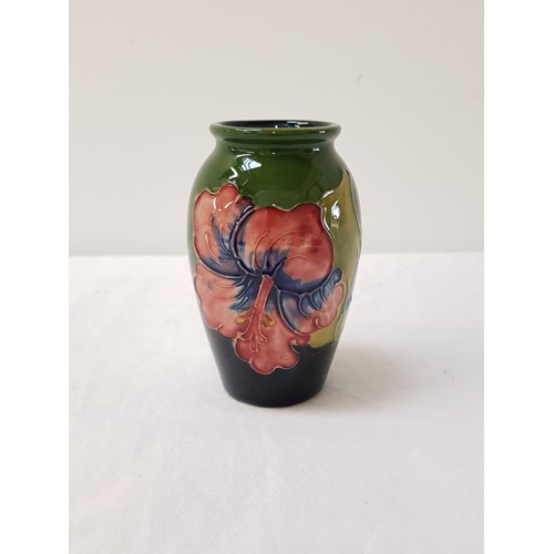 233 - MOORCROFT HIBISCUS PATTERN VASE
of ovoid form with a green ground and impressed mark to base, 10.5cm... 