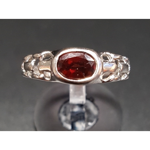 104 - GARNET SINGLE STONE RING
the bezel set oval cut garnet on fourteen carat white gold shank with decor... 