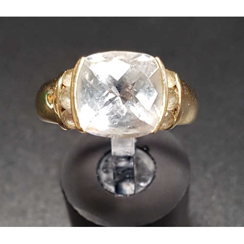 114 - CLEAR GEM SET DRESS RING
the central faceted top cushion cut gemstone flanked by further small stone... 