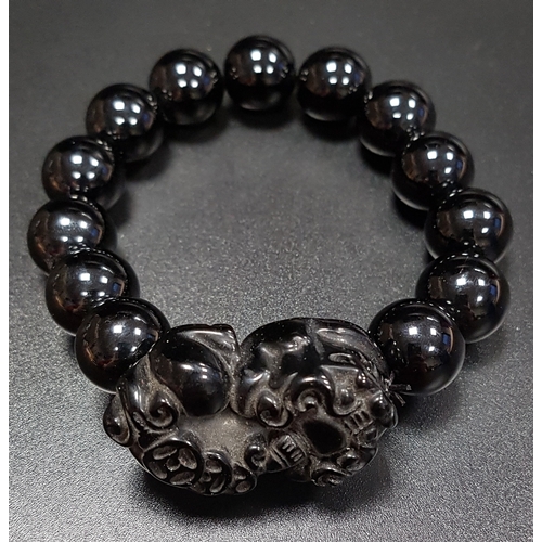 168 - ONXY BEAD BRACELET
comprising thirteen beads and a carved dog of foe style section