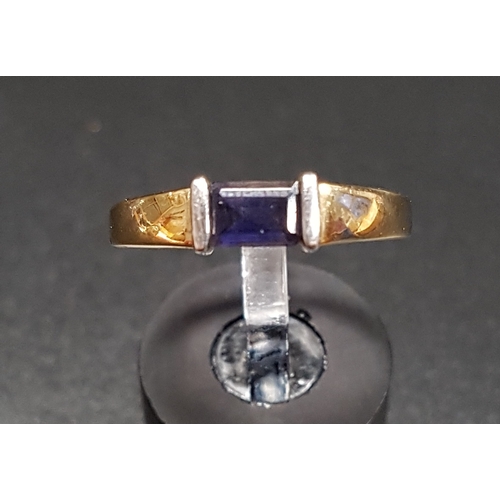 171 - IOLITE SINGLE STONE RING
the emerald cut gemstone flanked by white gold linear mounts, on nine carat... 