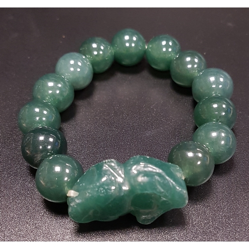 184 - GREEN AGATE BEAD BRACELET
comprising thirteen beads and a carved dog of foe style section