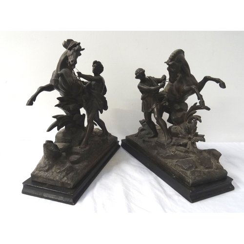 374 - TWO SPELTER FIGURINES
each depicting a man trying to control a rearing horse, raised on ebonised rec... 