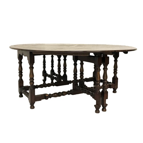 518 - VERY LARGE OAK GATELEG TABLE
with shaped drop flaps, standing on turned supports united by stretcher... 