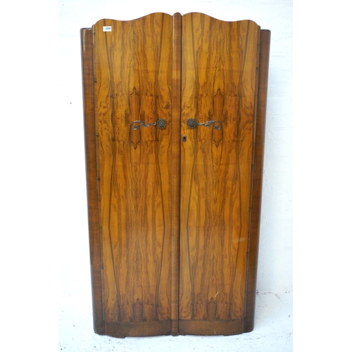 370 - WALNUT VENEERED WARDROBE
with a pair shaped doors opening to reveal a hanging rail and shelves marke... 