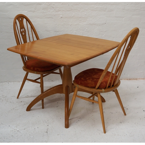 338 - ERCOL LIGHT OAK DINNING TABLE
with a pull apart top revealing a fold out leaf, with a turned shaped ... 