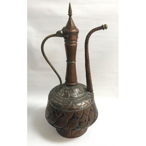 253 - LARGE MIDDLE EASTERN COPPER COFFEE POT
with a decorative hammered body, elongated neck, spout and ha... 