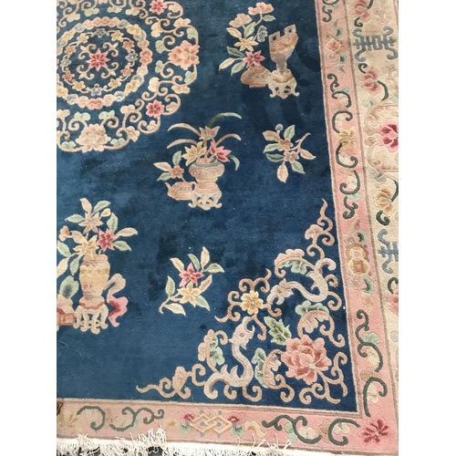 420 - LARGE CHINESE STYLE RUG
with a Royal blue ground decorated with floral motifs, encased in a floral p... 